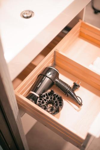 a hair dryer in a wooden box in a drawer at Laurentroom Center in Ukmergė