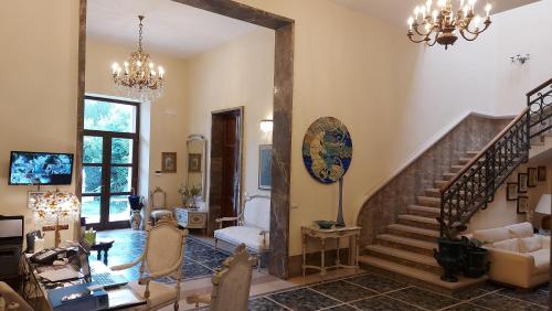 a living room with a staircase and a chandelier at Dimora Charleston Lecce parcheggio privato in loco gratis in Lecce