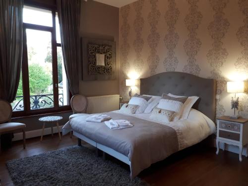 CaudryにあるLe Manoir de la mantilleのベッドルーム(大型ベッド1台、大きな窓付)