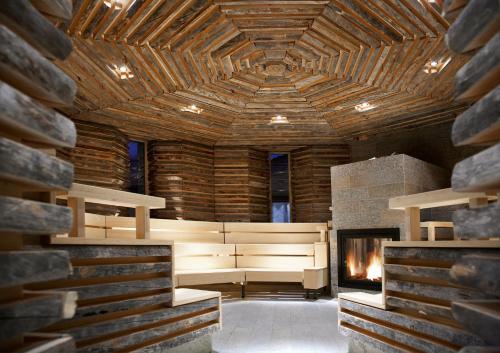a large room with a fireplace and a wooden ceiling at Tschuggen Grand Hotel - The Leading Hotels of the World in Arosa
