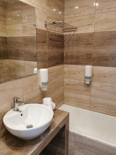 a bathroom with a sink and a bath tub at Cyprotel Faliraki in Faliraki