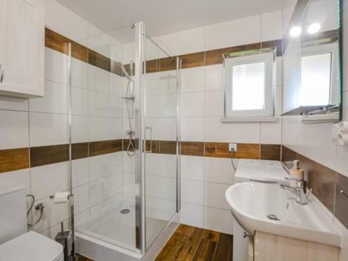 La salle de bains est pourvue d'une douche, de toilettes et d'un lavabo. dans l'établissement Czadzia Przystań, à Czarna