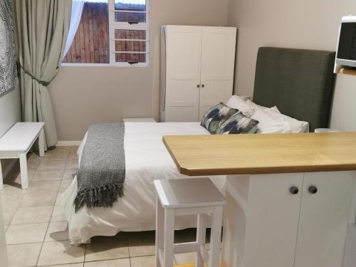 a small bedroom with a bed and a desk at 65at3rd in Newton Park