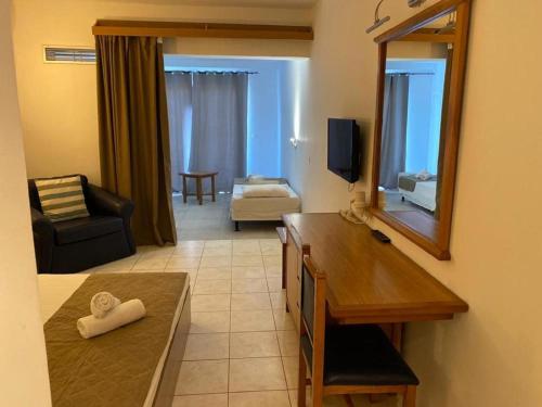 a living room with a table and a mirror and a couch at Cyprotel Faliraki in Faliraki