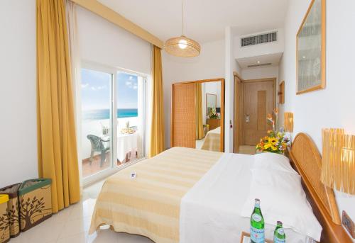 una camera con letto e vista sull'oceano di Ecoresort Le Sirene - Caroli Hotels a Gallipoli