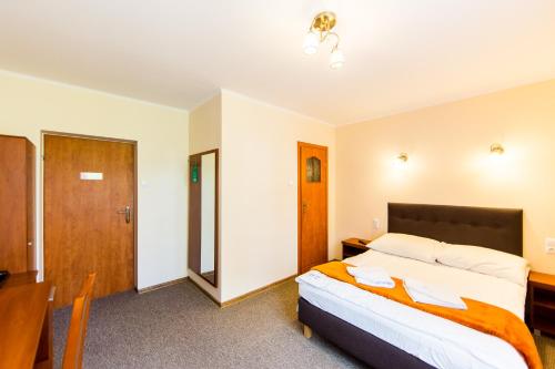 a bedroom with a bed and a desk and a table at "Hel" Wieniec Zdrój in Włocławek