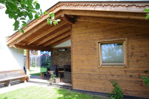 a wooden building with a window and a bench at Appartement Wälderhof in Kaprun