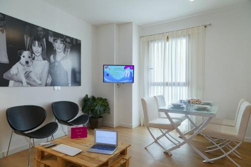 a living room filled with furniture and a tv at Caleta Homes - Apartamentos Pompidou in Málaga
