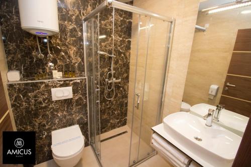 a bathroom with a shower and a toilet and a sink at Hotel Amicus in Mostar