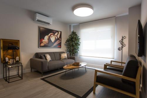 a living room with a couch and a table at Caleta Homes - Ancha del Carmen in Málaga