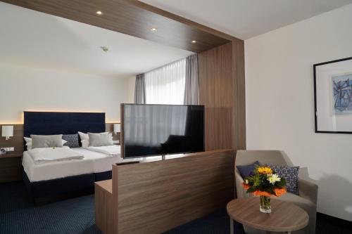 a hotel room with a bed and a television at Alexander am Zoo in Frankfurt/Main