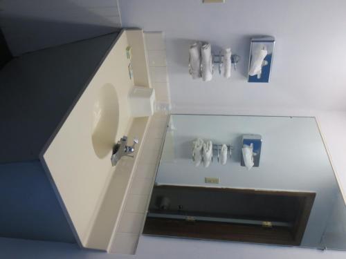 a bathroom with a sink and some pictures on the wall at Budget Inn Adair in Adair