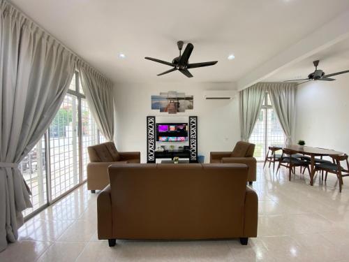 a living room with a couch and a table at Langkawi Cozy Holiday Home at Bukit Indah by Zervin in Kuah