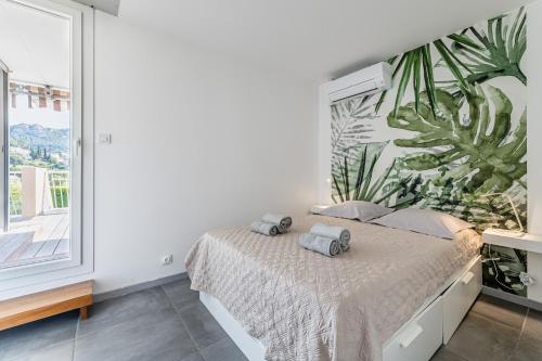 Un dormitorio con un gran mural de plantas en la pared. en Le Canaio Upper Club par Dodo-a-Cassis, en Cassis