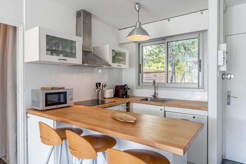 - une cuisine avec un comptoir, un four micro-ondes et des chaises dans l'établissement Le Canaio Upper Club par Dodo-a-Cassis, à Cassis