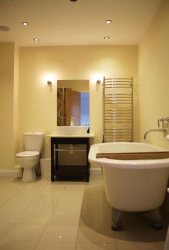 a bathroom with a tub and a toilet and a sink at Pirn Mill Self Catering Cottage in Cladich