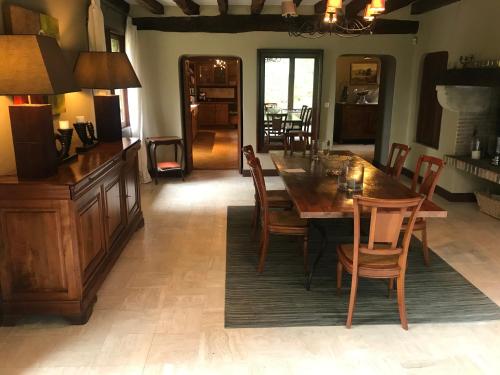 une salle à manger avec une table et des chaises en bois dans l'établissement Domaine des Courtils, à Romorantin-Lanthenay