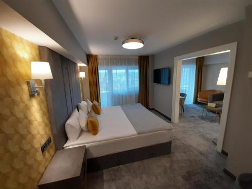 a bedroom with a large bed and a living room at Univers T Hotel in Cluj-Napoca