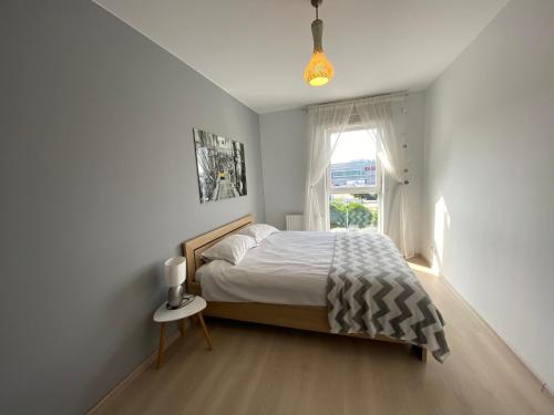 グダニスクにあるAnn Apartament 4 Oceanyの白いベッドルーム(ベッド1台、窓付)