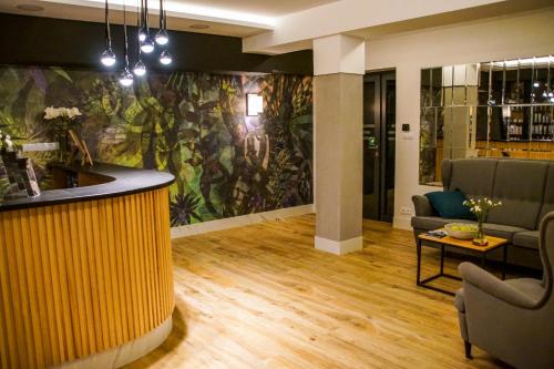 a lobby with a bar with a tropical mural on the wall at Navigator Hotel i Konferencje in Zbąszyń