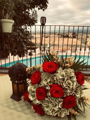a bouquet of red roses on a table near a pool at Agriturismo Serra San Biagio in Calatabiano