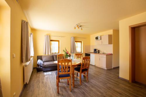 a kitchen and a dining room with a table and chairs at Pension Ferienhof Fischer in Freiberg