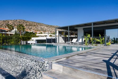 una piscina di fronte a una casa di Black Diamond Luxury Beachfront Villa Selenia a Sounio