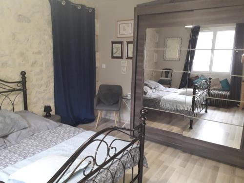 um quarto com 2 camas e um espelho em Maison de la Gare em Tombeboeuf