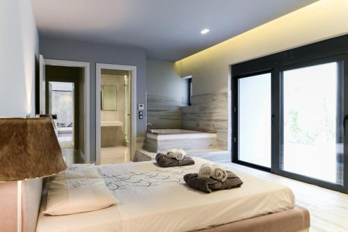 una camera da letto con un letto grande con asciugamani sopra di Black Diamond Luxury Beachfront Villa Selenia a Sounio