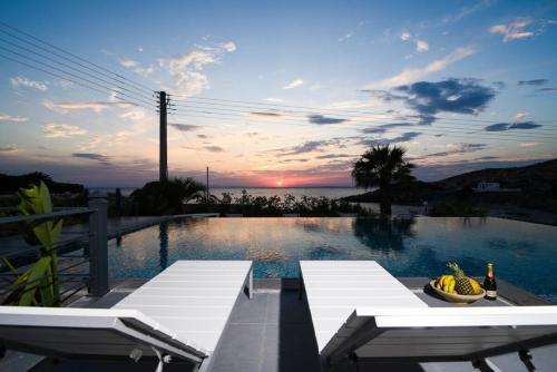 a swimming pool with a table and a bowl of fruit at Luxury Beachfront Villa Selenia Platinum in Sounio in Sounio