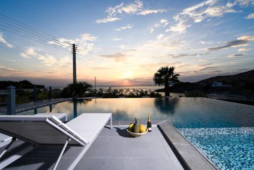 a swimming pool with a table with a bowl of fruit on it at Luxury Beachfront Villa Selenia Platinum in Sounio in Sounio