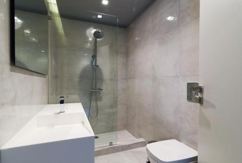 a bathroom with a shower and a sink and a toilet at Luxury Beachfront Villa Selenia Platinum in Sounio in Sounio