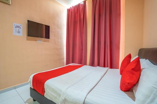 - une chambre avec un lit doté d'oreillers rouges et une télévision dans l'établissement OYO 89328 Sz Hotel, à Lumut