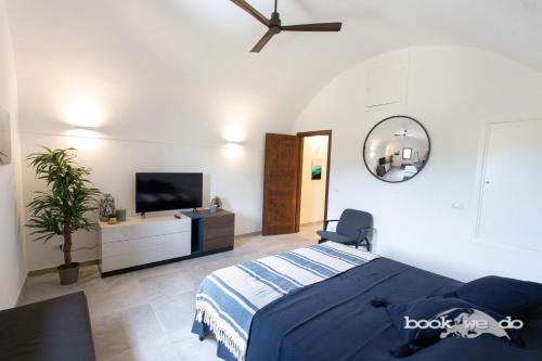 - une chambre avec un lit et une télévision à écran plat dans l'établissement La Rocca 2 - Bookwedo, à Porto Ercole