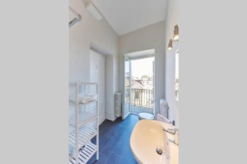 uma casa de banho com um lavatório branco e uma janela em Domus Mazzini em Turim
