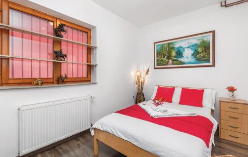 a bedroom with a red and white bed and windows at Vila NINA in Gospić