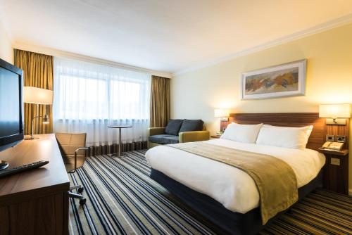 a hotel room with a bed and a television at Holiday Inn Ashford Central by IHG in Ashford