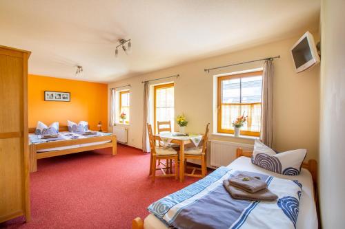 a bedroom with a bed and a table and a desk at Pension Ferienhof Fischer in Freiberg