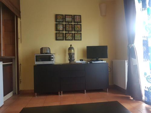 a living room with a television and a microwave at Casa Beatriz in Cala San Vicente