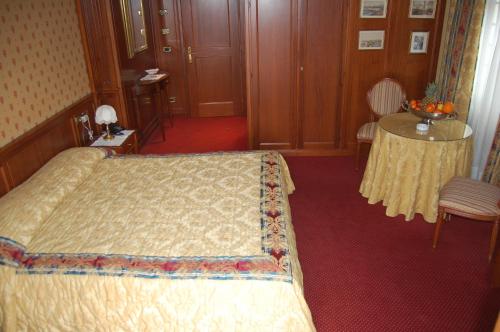 a hotel room with a bed and a table at Hotel Olympic in Saint Vincent
