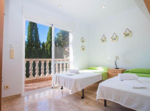 - 2 lits dans une chambre avec une grande fenêtre dans l'établissement Villa Canuta - Plusholidays, à Calp