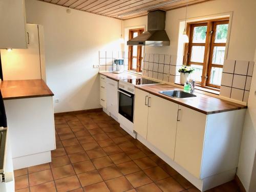 a kitchen with white cabinets and a sink at Torvet 19 - Maribo in Maribo