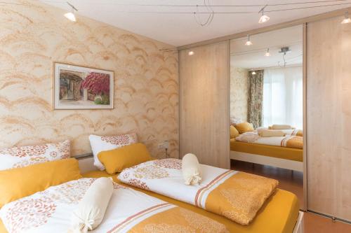 a bedroom with two beds and a mirror at Ferienwohnung Marianne in Radolfzell am Bodensee