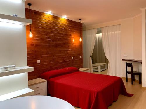 um quarto com uma cama vermelha e uma parede de tijolos em Casa Claudia - Pool and Wifi em Silves