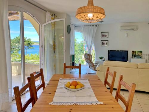 ein Wohnzimmer mit einem Tisch und einer Obstschale darauf in der Unterkunft Apartments Savic in Šilo