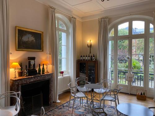 sala de estar con mesa, sillas y chimenea en La Villa by Michel Gonet, en Épernay