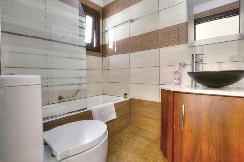 a bathroom with a toilet and a sink and a tub at Seafront Protaras Villas in Protaras