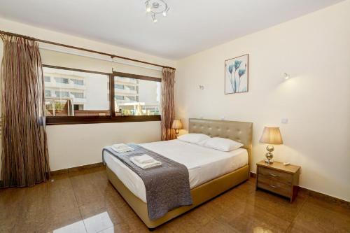 a bedroom with a large bed and a window at Seafront Protaras Villas in Protaras