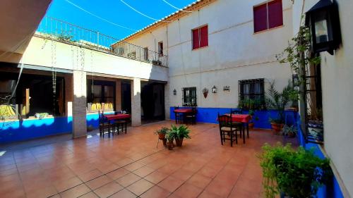 an outdoor patio with tables and chairs in a building at Hotel Rural Posada Los Caballeros in Almagro