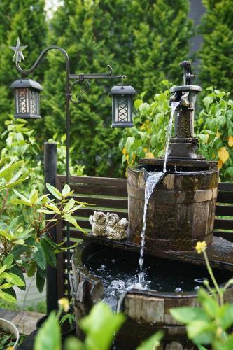 a water fountain with two lights on a park bench at Kakureyado Fujikawaguchiko in Fujikawaguchiko